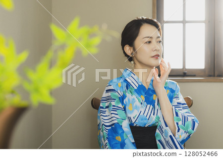 A woman in a yukata by the window A woman in a yukata by the window 128052466