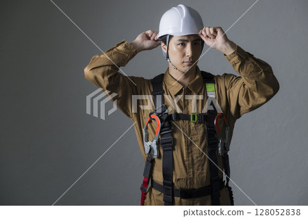 Male worker wearing a full harness 128052838