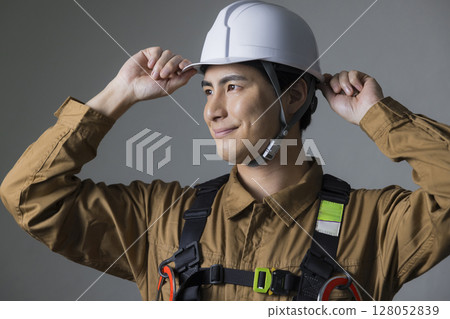Male worker wearing a full harness 128052839
