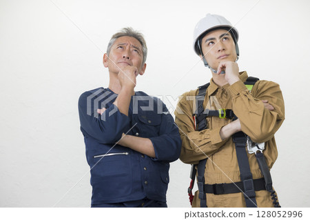 Male worker wearing a full harness 128052996