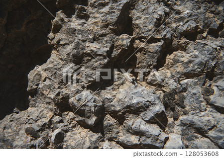 Rugged Natural Stone Surface Capturing Texture and Detail on a Bright Day 128053608