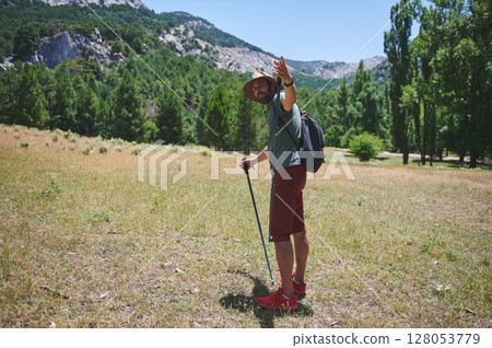 Traveler Exploring Mountain Trails During a Sunny Summer Day in the Wilderness Traveler Exploring Mountain Trails During a Sunny Summer Day in the Wilderness 128053779