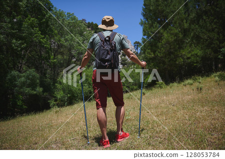 Hiker Exploring Mountain Trail with Backpack During Summer Day in Nature Hiker Exploring Mountain Trail with Backpack During Summer Day in Nature 128053784