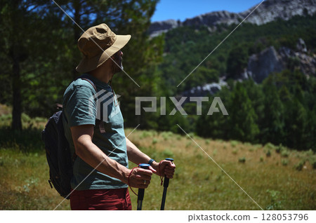 Man Hiking in a Scenic Mountain Landscape Wearing Outdoors Attire 128053796