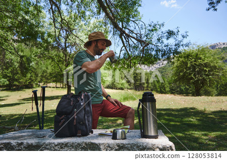 Traveler Relaxing with Drink Outdoors in a Scenic Mountain Setting 128053814