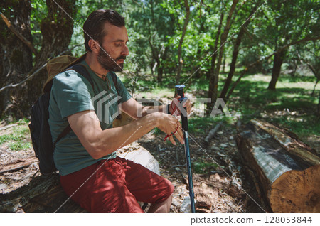 Man Hiking in Forest with Backpack and Trekking Pole in Summer 128053844