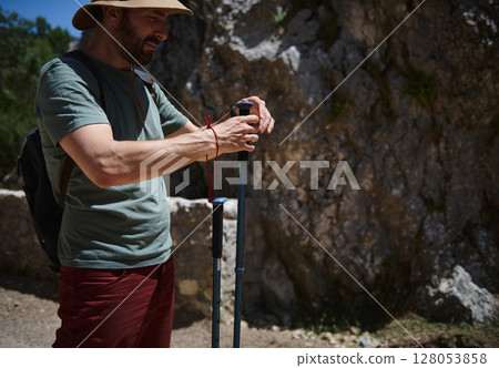 Adult Male Hiker Preparing for an Adventure with Trekking Poles in a Rocky Mountain Setting Adult Male Hiker Preparing for an Adventure with Trekking Poles in a Rocky Mountain Setting 128053858