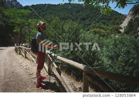 Bearded Man Hiking Along a Scenic Trail in the Mountains on a Summer Day Bearded Man Hiking Along a Scenic Trail in the Mountains on a Summer Day 128053864
