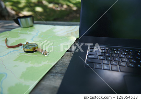 Outdoor Navigation Setup Featuring Map, Compass, and Laptop on a Wooden Table Outdoor Navigation Setup Featuring Map, Compass, and Laptop on a Wooden Table 128054518