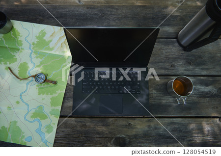 Outdoor Workstation Setup with a Laptop, Map, Compass, and Tea Outdoor Workstation Setup with a Laptop, Map, Compass, and Tea 128054519