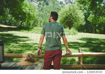 Man Enjoying Scenic Nature Setting During a Hike on a Bright Summer Day 128054543