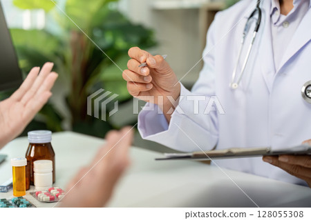 Medication Discussion. Doctor explaining prescription to patient during consultation. 128055308