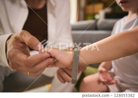 Timeless style. Father adjusting child wristwatch in warm, intimate father-child moment 128055382