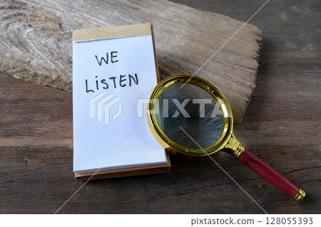 We listen text written on a notebook and magnifying glass. We listen text written on a notebook and magnifying glass. 128055393