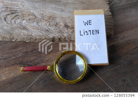 We listen text written on a notebook and magnifying glass. 128055394