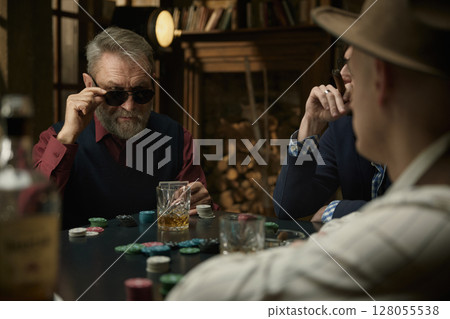 Serious determined man thinking about the course of the poker game in a vintage bar 128055538