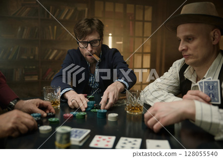 Live poker game featuring company of men with cigar and alcohol beverages 128055540
