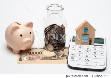 Pig money box, calculator and coins in a jar 128055986