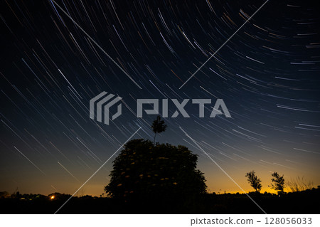 Amazing Night Landscape With Star Trails Moving On A Night Sky And Silhouette Of Tree Amazing Night Landscape With Star Trails Moving On A Night Sky And Silhouette Of Tree 128056033