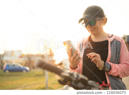 Woman Checking Bike Route On A Smartphone With Gps Map on city street 128056075