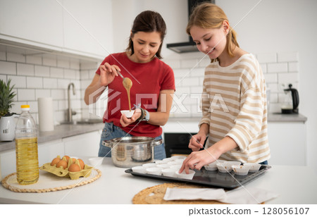 Happy Little Girl And Mother Baking Muffins In The Kitchen Happy Little Girl And Mother Baking Muffins In The Kitchen 128056107