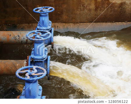 Industrial drainage system with five blue pipes discharging water into a reservoir. Concept of water management, wastewater treatment, and environmental engineering, spillway 128056122