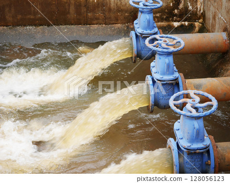 Industrial drainage system with five blue pipes discharging water into a reservoir. Concept of water management, wastewater treatment, and environmental engineering, spillway Industrial drainage system with five blue pipes discharging water into a reservoir. Concept of water management, wastewater treatment, and environmental engineering, spillway 128056123