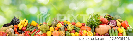 Photo of bright healthy fruits, vegetables and berries on a green natural background. Photo of bright healthy fruits, vegetables and berries on a green natural background. 128056408