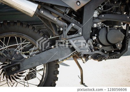 Detailed view of a motorcycle's engine components and frame taken during a repair session in a workshop 128056606