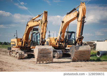 Construction machinery working on site during bright day with clear sky and scattered clouds Construction machinery working on site during bright day with clear sky and scattered clouds 128056631