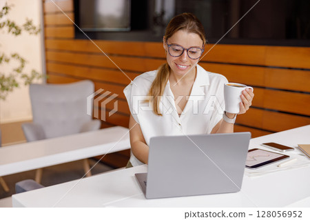 A young professional diligently working remotely using a laptop in a modern workspace environment A young professional diligently working remotely using a laptop in a modern workspace environment 128056952