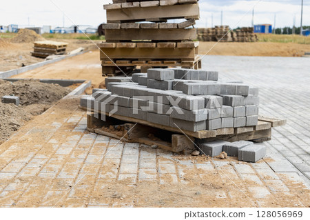 Storage of paving slabs on pallets at the construction site. Ready-to-install concrete paving slabs. Finished products warehouse. 128056969