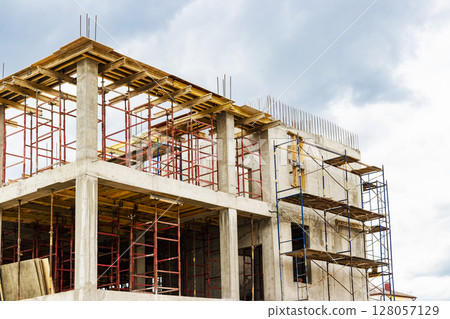 Construction of a new monolithic reinforced concrete house. Formwork for pouring the next floor. Working at height on a construction site. 128057129