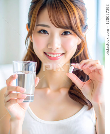 一名年輕女子喝酒補充劑 一名年輕女子喝酒補充劑 128057398