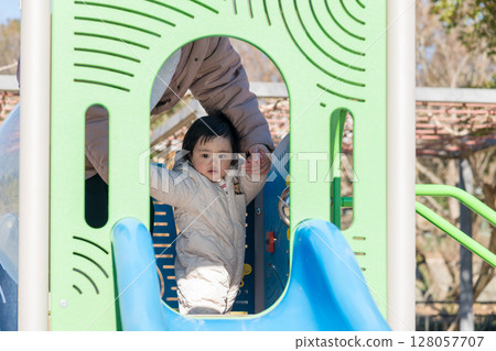 [一歲兒童與母親在相模原市麻溝公園的兒童遊樂場玩耍] 128057707