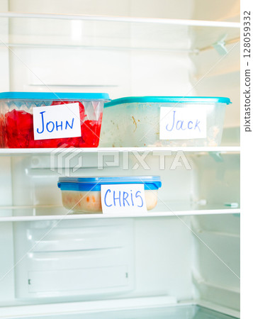 Handwritten names on reusable food containers in work fridge. Image for eco friendly office initiatives. Handwritten names on reusable food containers in work fridge. Image for eco friendly office initiatives. 128059332