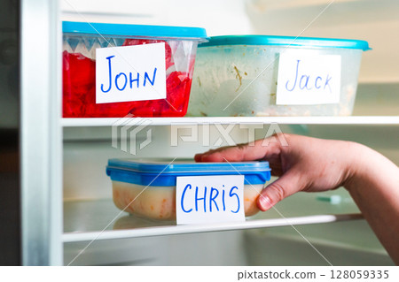 Meal prep containers in office refrigerator. Ideal for time management content, and efficient workspace setups. 128059335