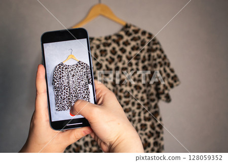 Female influencer prepares used garments for resale. Online second hand shop. Fashion circulation. 128059352