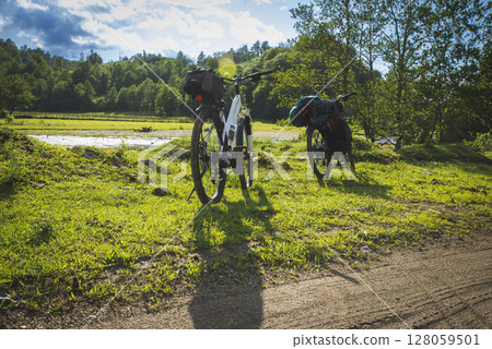 Cyclist with a saddle bag near a lake. Traveler on bicycle on sunny day 128059501