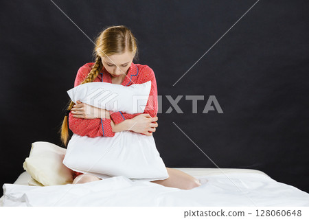 Sad depressed girl in bed gripping pillow Sad depressed girl in bed gripping pillow 128060648