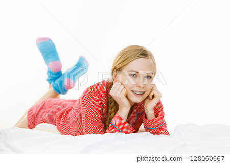 Smiling woman lying in bed Smiling woman lying in bed 128060667