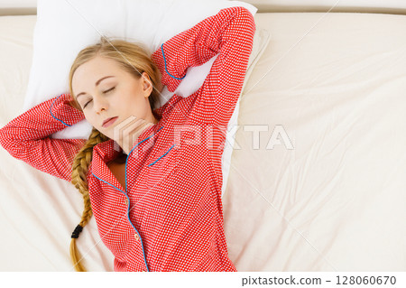Woman sleeping in bed on back 128060670