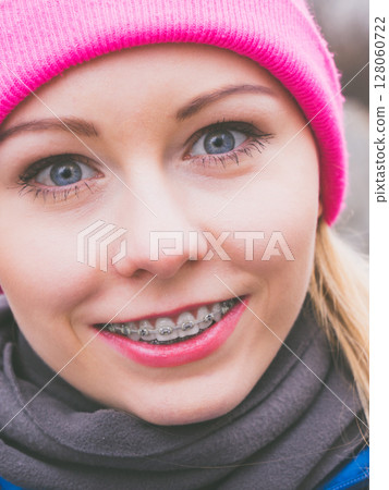 Smiling woman wearing pink beanie 128060722