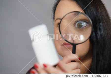 Woman investigating ingredients of medicines 128061617