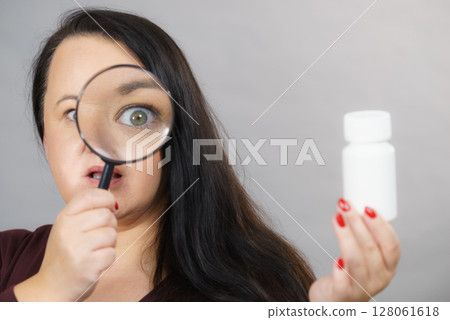 Woman investigating ingredients of medicines 128061618