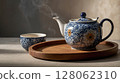 Steaming teapot and teacup on wooden tray creating cozy atmosphere 128062310