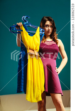 woman customer holding hangers with clothes 128062519