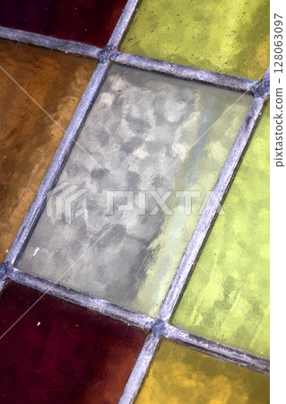 Close up abstract square stained glass window sections multicoloured background Close up abstract square stained glass window sections multicoloured background 128063097