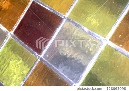 Close up abstract square stained glass window sections multicoloured background Close up abstract square stained glass window sections multicoloured background 128063098