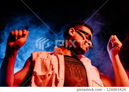 Stylish Man Dressed In Net Dancing In Neon Light, Smoke Studio Or In Night Club Stylish Man Dressed In Net Dancing In Neon Light, Smoke Studio Or In Night Club 128063426
